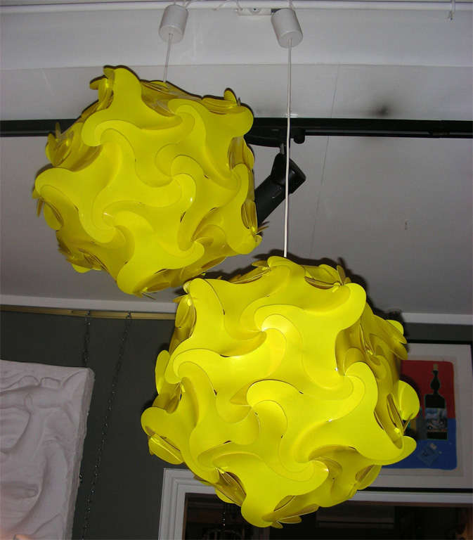 Two 1970s yellow plastic chandeliers, with adjustable length of cable.