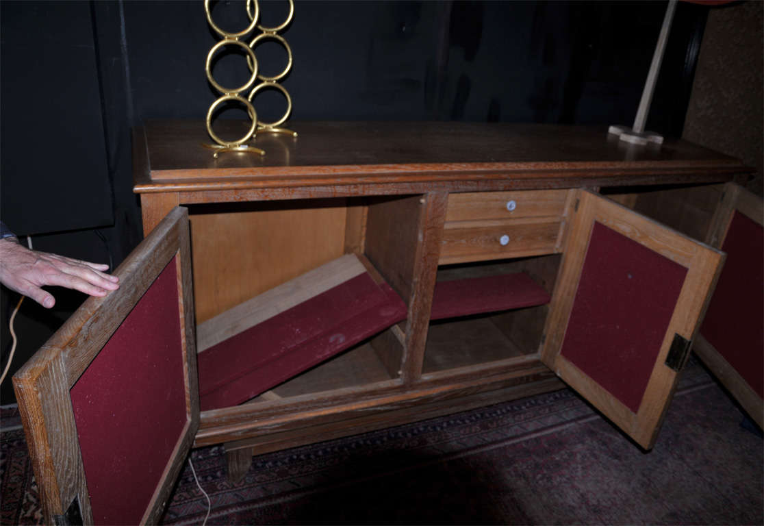 1940s buffet attributed to René Prou in cerused oak, red leather and bronze. Two interior drawers and one shelf.