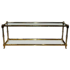 An elegant brass two tiers console table.