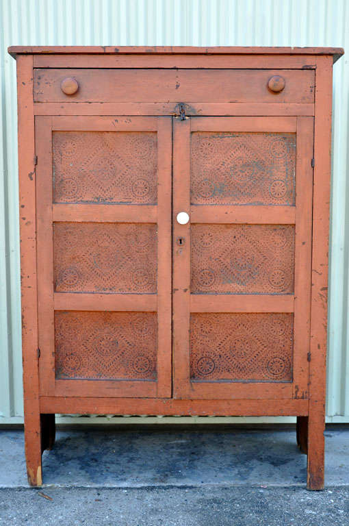 FANTASTIC 19THC ORIGINAL PAINTED TWO DOOR PIE SAFE IN BITTERSWEET PAINT.THIS ONE DRAWER OVER TWO DOOR PUNCHED TIN PANELS WITH ALL ORIGINAL HARDWARE AND IRONSTONE KNOB PULL IS IN GREAT CONDITION.THE SIDES HAVE GREAT CUT OUTS AND THE INTERIOR IS IN