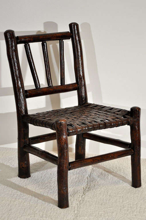 FOLKY CHILDS RUSTIC HICKORY CHAIR.THIS CHAIR HAS ITS ORIGINAL HICKORY SPLINT SEAT AND IS IN GREAT CONDITION.THE CHAIR HAS A DARK OLD SURFACE AND IS VERY STRONG AND STURDY.