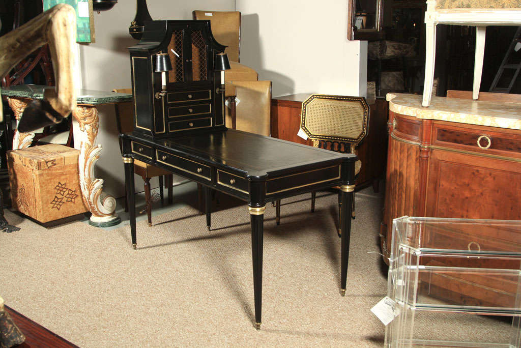 A fantastic overall ebonized, parcel-gilt, and bronze mounted French Cartonier, circa 1930  JANSEN, the secretary top with netted doors and drawers flanked by two reading lights, sitting on top of embossed leather top, over a frieze fitted with