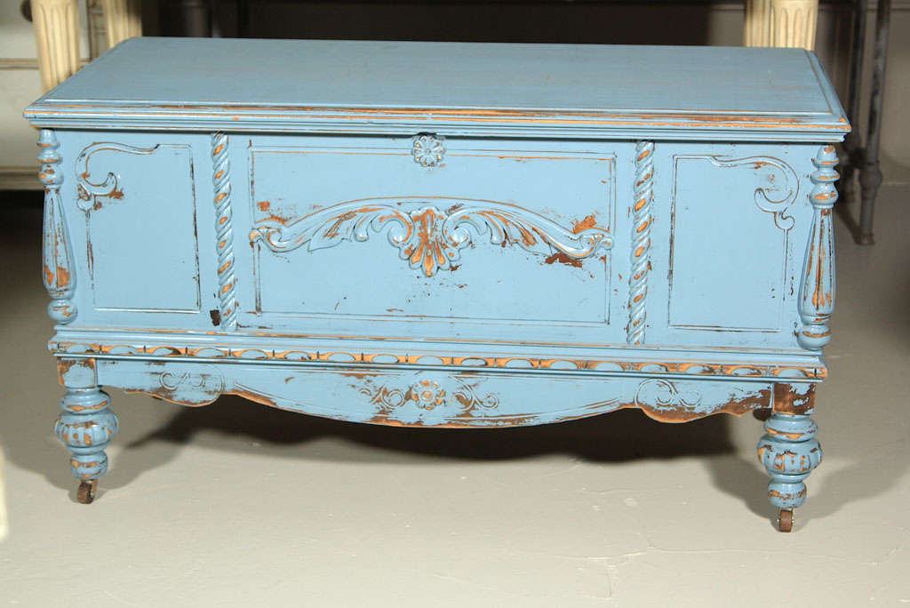 A very chic blue painted cedar linen trunk in the style of French Louis XVI by Lane Co., circa 1920s with original Lane stickers intact and folded shelving system. Raised on bulbous feet and casters.