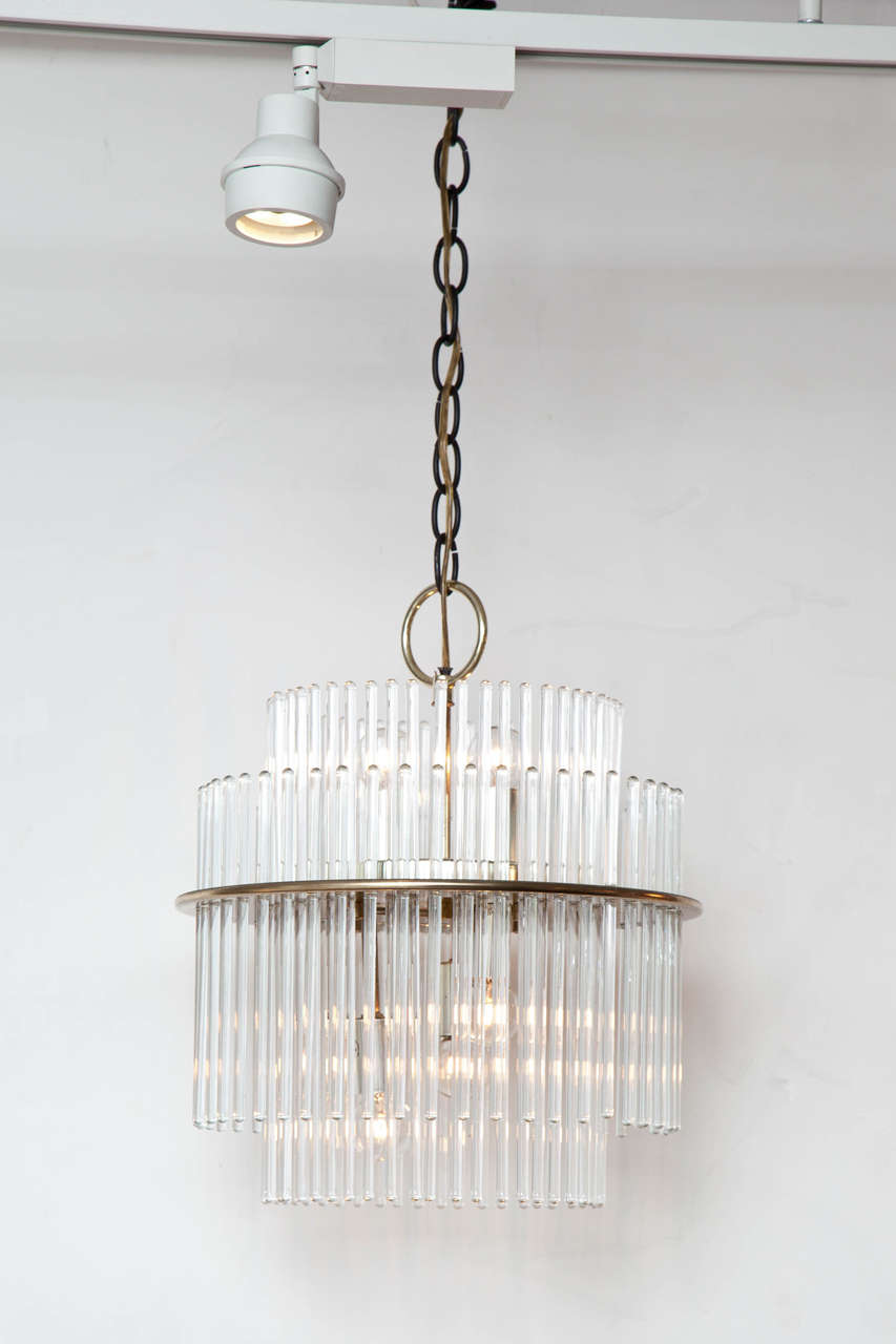 Elegant chandelier with glass rods suspended from a two-tier, round brass frame.  By Gaetano Sciolari for Lightolier. USA, circa 1960.  Unsigned.  Coordinating wall sconces available; please inquire.