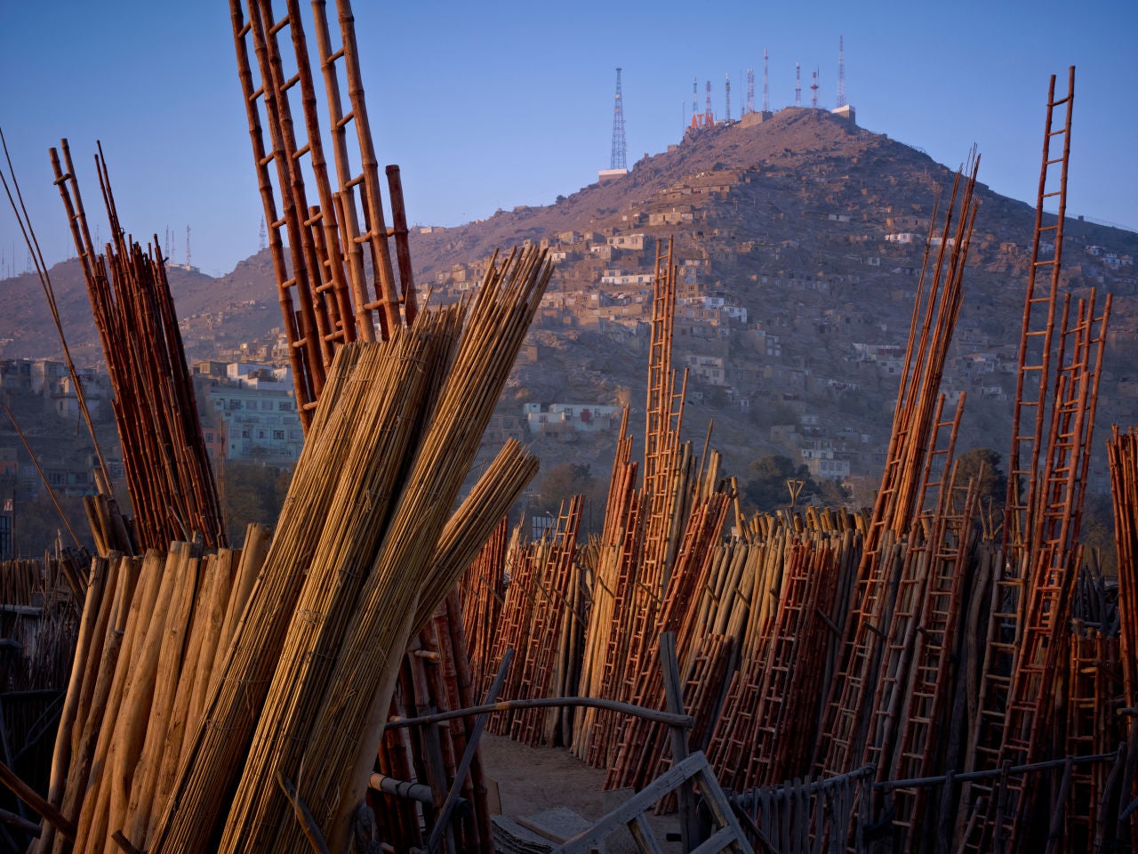 Simon Norfolk Landscape Photograph - Shop For Construction Materials. American Surveillance Antennae On The Hills, Kabul