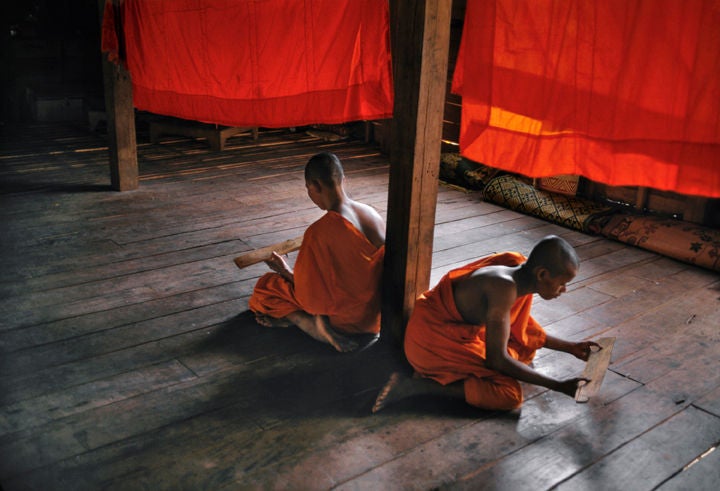 Novice Monks Studying, Monastery, Angkor Wat - Photograph by Steve McCurry