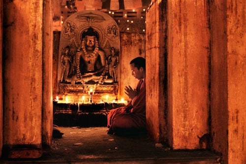 Steve McCurry Color Photograph - Monk praying at Bodh Gaya