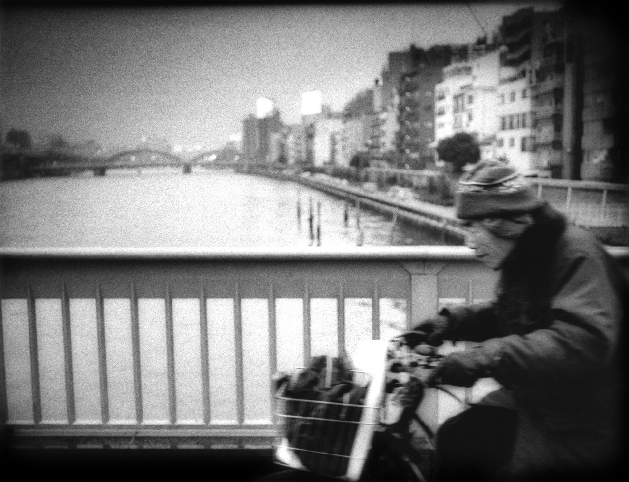 James Whitlow Delano Landscape Photograph - Cycling across Sumida River Bridge in Ueno, Tokyo