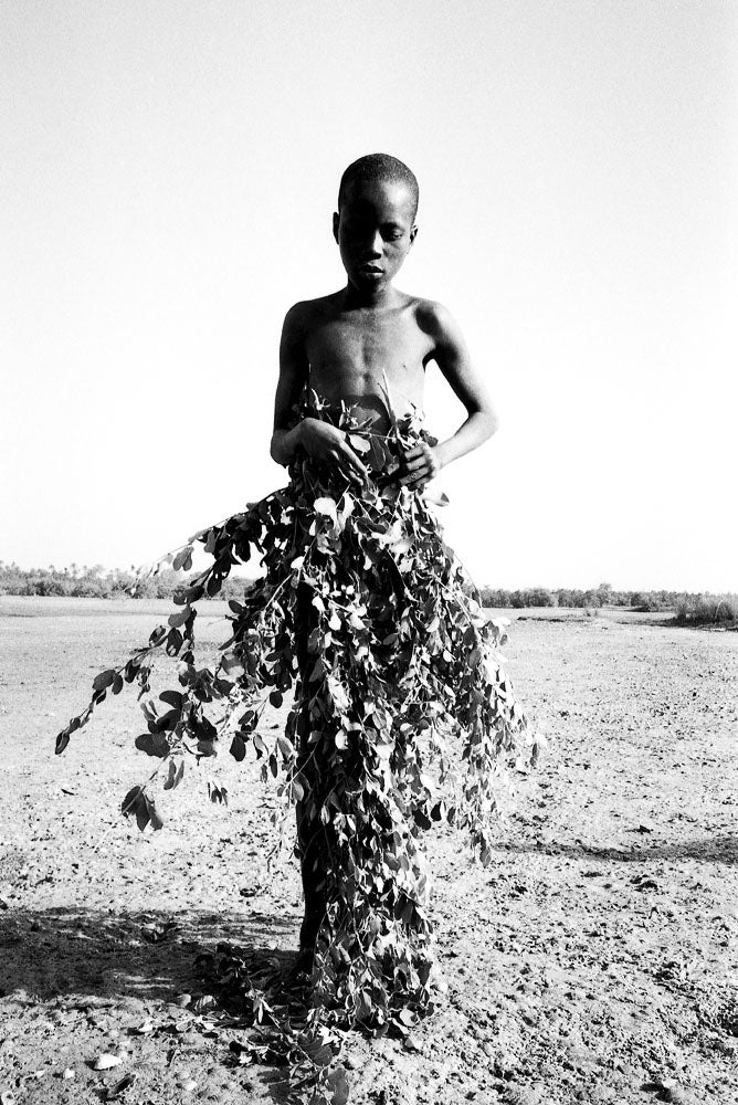 Young boy, preparing to wash at the river, after male circumcision ceremony - Photograph by Jason Florio