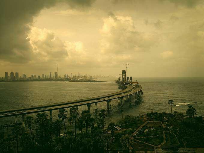 Andreas H. Bitesnich Landscape Photograph – Rajiv Gandhi Sea Link, Mumbai 2007 - Brücke, Wasser, Wolken und die Stadt zeigt