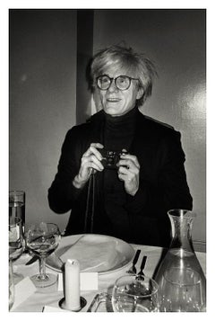 Andy Warhol, NY 1985, le célèbre artiste tenant un appareil photo au dîner