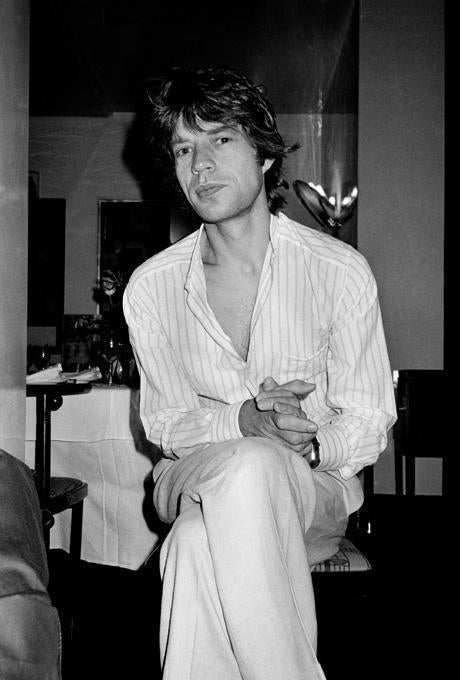 Roxanne Lowit Black and White Photograph - Mick Jagger Pleased, NYC the rockstar sitting in a pyjama on chair in hotelroom