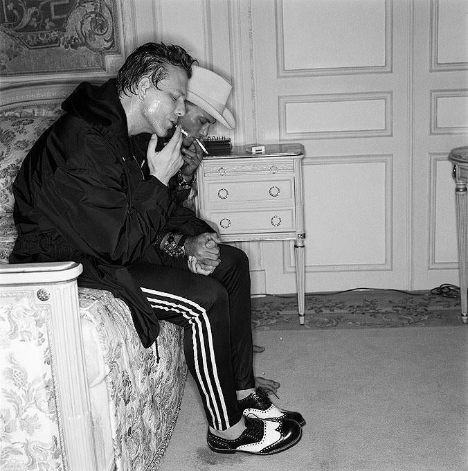 Michel Comte Black and White Photograph - Mickey Rourke, the actor on hotel bed smoking a cigarette 