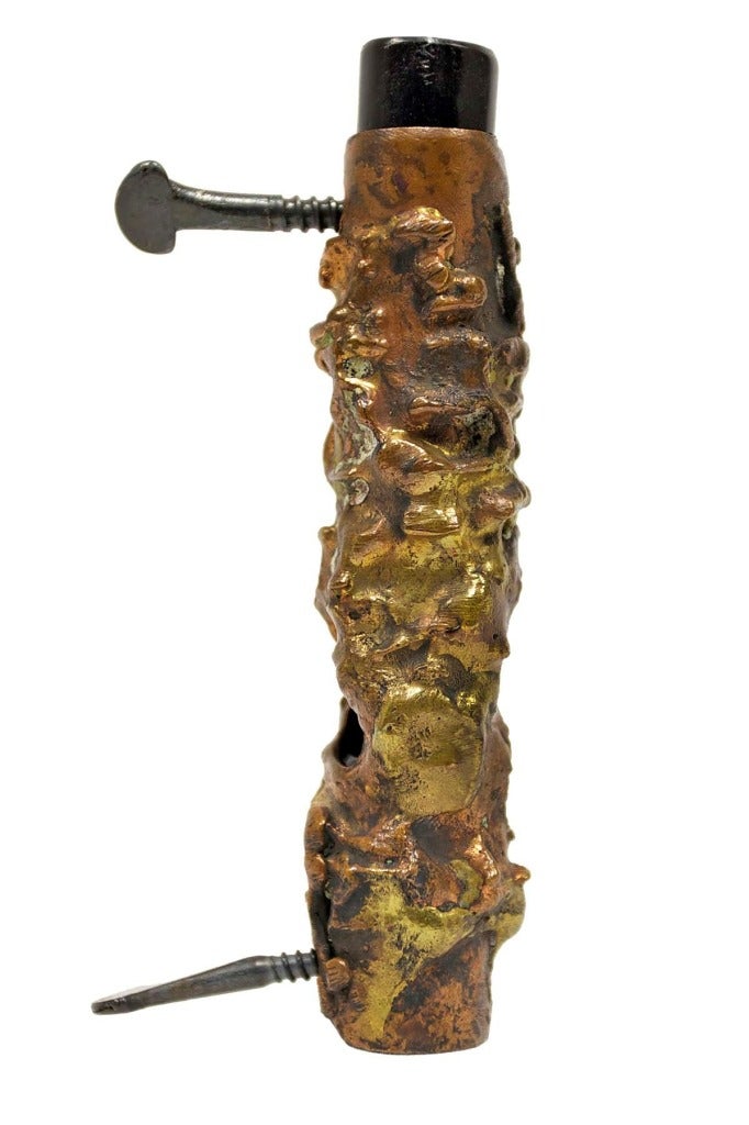 This is a Mezuzah case by the artist David Palombo. A Mezuzah is is a piece of parchment (often contained in a decorative case) inscribed with specified Hebrew verses from the Torah (Deuteronomy 6:4-9 and 11:13-21). This bronze Mezuzah case