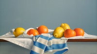 Zitronen und Oranges mit gestreiftem Tuch