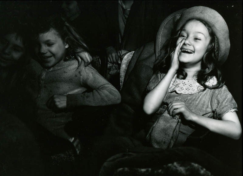 Girl Wearing Hat Laughing in Movie Theater, ca. 1945 - Photograph by Weegee