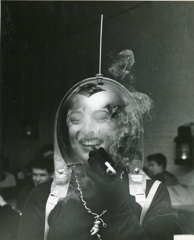 Woman in a Space Helmet Smoking a Cigarette, ca. 1950 - Photograph by Weegee