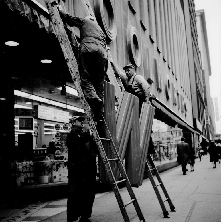 Vivian Maier Black and White Photograph - Workmen with Woolworth's Sign, 1968