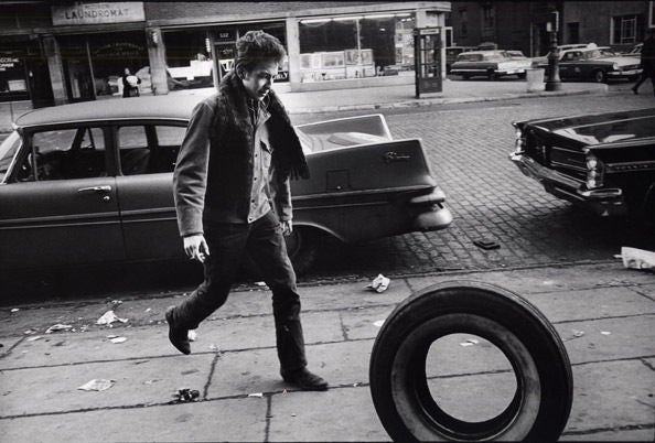 Jim Marshall Figurative Photograph - Bob Dylan with Tire, 1963
