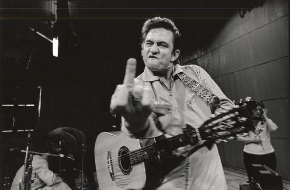 Jim Marshall Black and White Photograph - Johnny Cash, (Flipping the Bird), San Quentin Prison, 1969