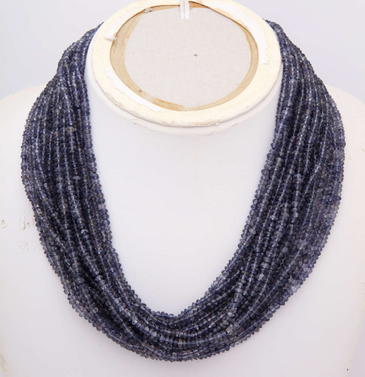 Iolite is a blue stone often mistaken for sapphire. There are 20 strands of faceted 3-5 mm beads. The beads sparkle beautifully.The clasp  is 14kt and 18 kt and closes with a hook and a figure 8 safety. The shortest strand is 16 in. and the longest