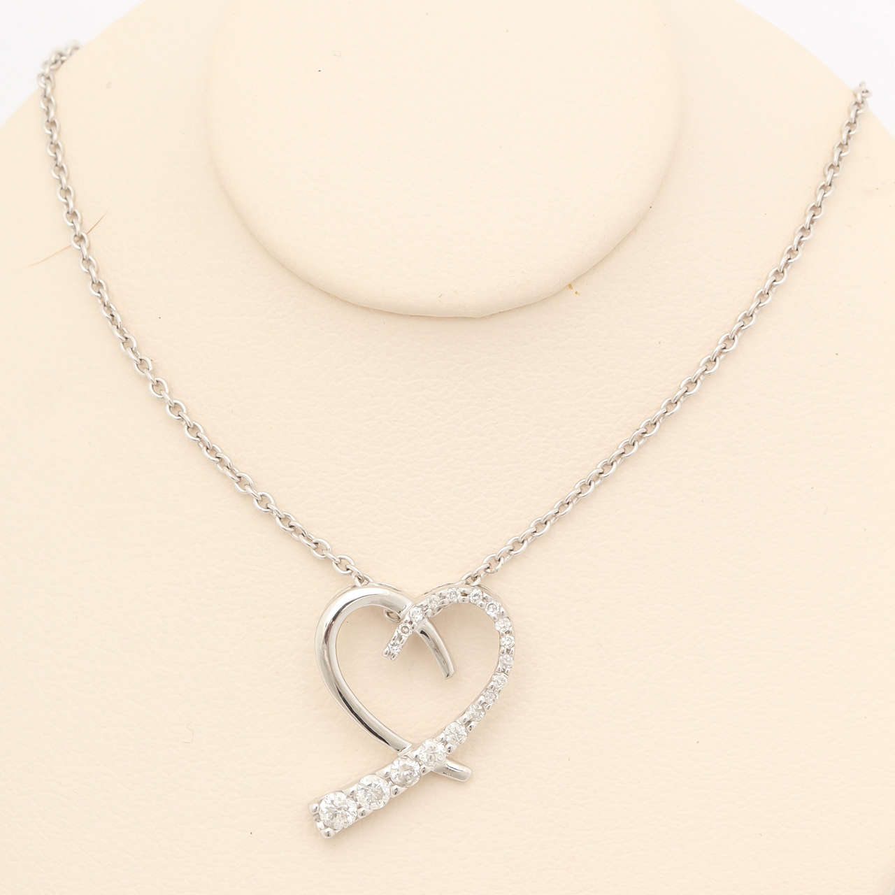 A sweet gift for any occasion; 14 kt white gold and 0.25 ct diamond pendant heart necklace. This necklace symbolizes love's journey, 18 diamonds graduated from the smallest to the largest in an eye-catching heart shape. The pendant is suspended from