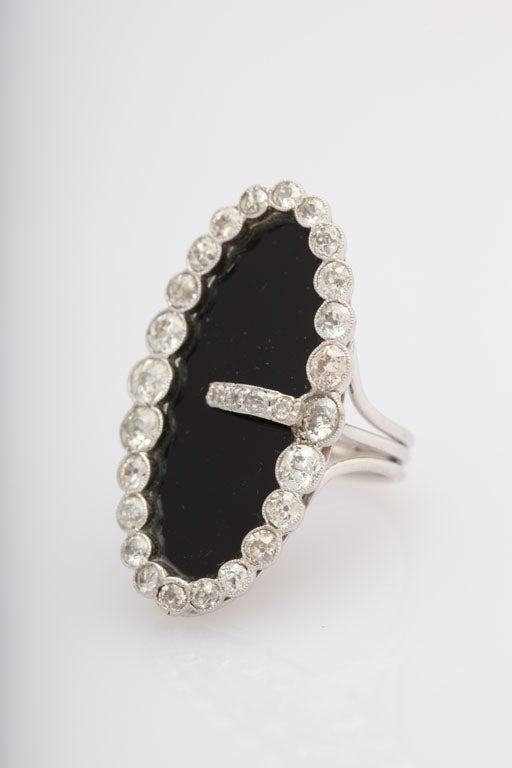 Elegant Buckle Ring was originally a platinum and diamond buckle brooch that was used on a ribbon necklace.  The onyx and 18k white gold shank were later added to make it into a ring.  It has approximately 3 carats of diamonds.

US Size 6