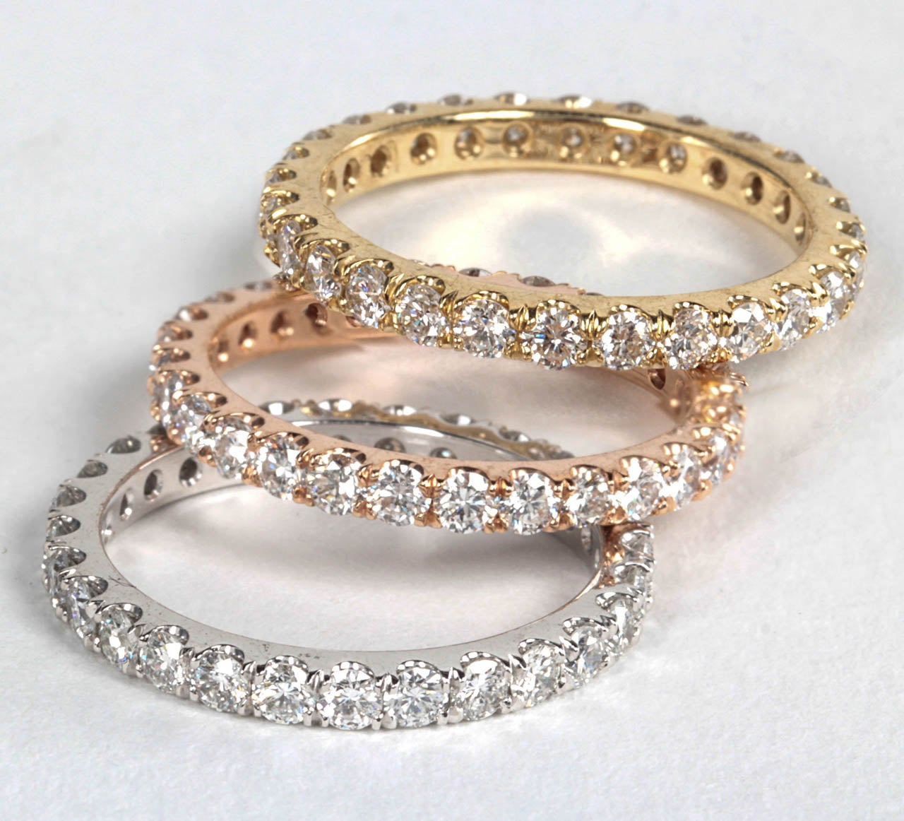 Three diamond eternity bands set in white, rose and yellow gold. 

The bands can be worn together or separately. 

3.65 carats of white round brilliant diamonds set in 14k gold.

Currently a size 6.5 -- Bands can be ordered to size.