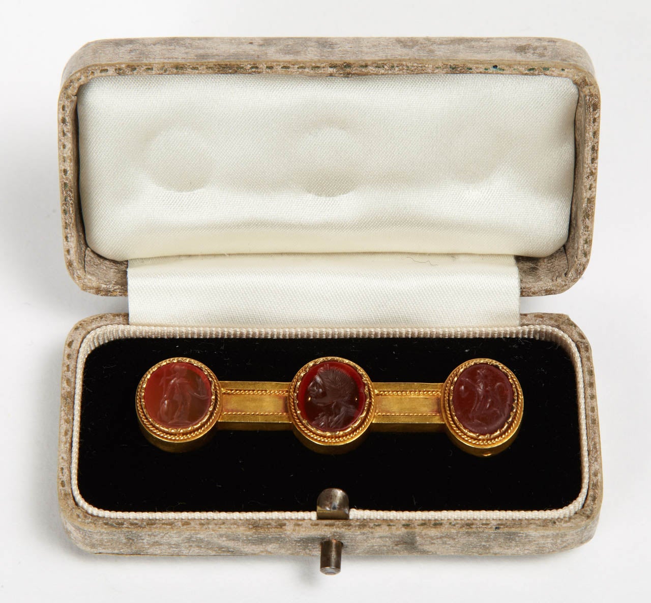 Antique gold brooch, in the Antique style revival of the 19th century set with 3 carnelian intaglios, Roman Period, engraved with the profile of Athena to the right, the bust of a laureled man towards the left and a dancing satyr (provenanceÂ :