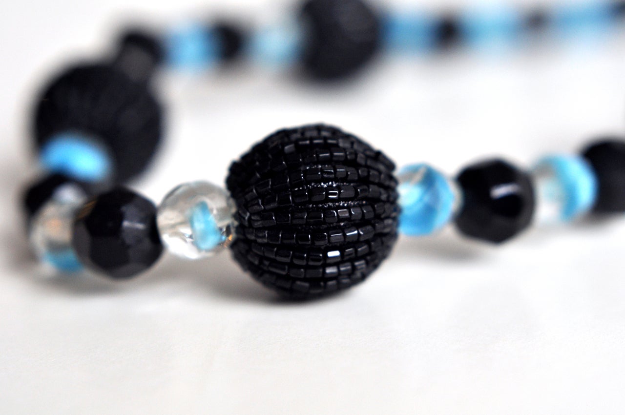 An early necklace by Christian Dior consisting of varied faceted beads. Beautiful color combination of black and clear crystal beads with varying shades of blue.  It retains the original tag that dates it to 1960.  Some flexibility on the length.