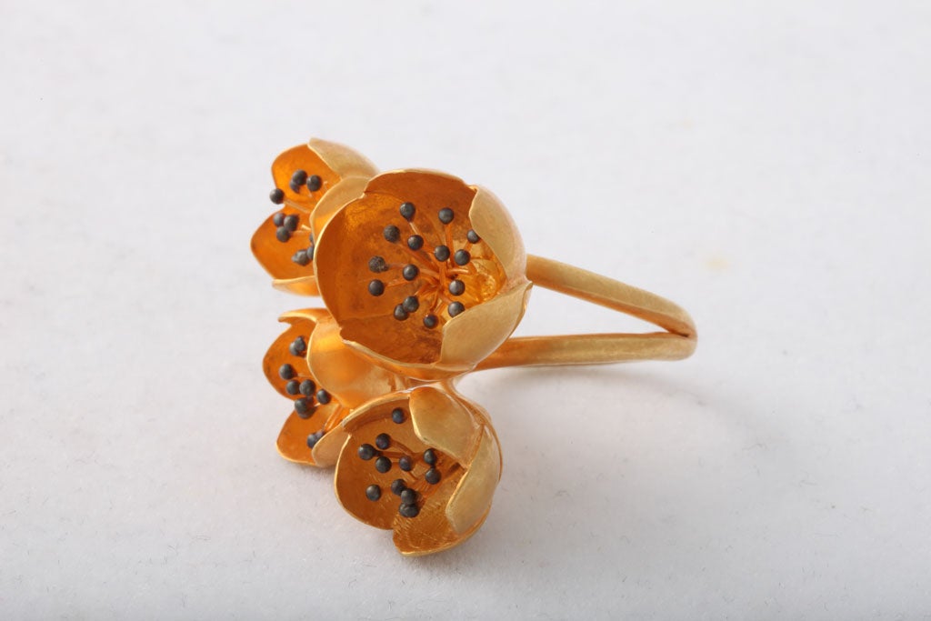 An 18kt yellow gold buttercup ring featuring four buttercups with sterling silver pistons. Size 7
Width: 1.80 inches
Flower height: .65 inch
