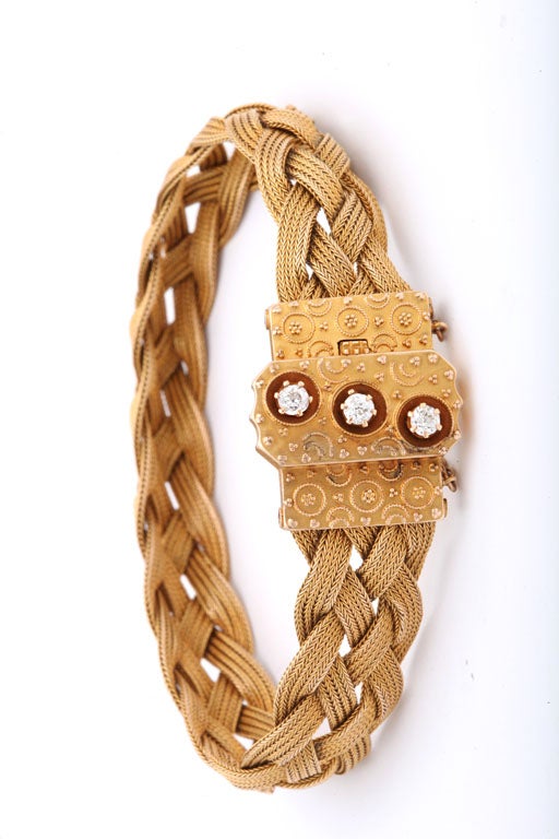Golden braids wrap around as the clasp with nested diamonds sits atop the wrist. Made to show, the closure, is sprinkled with small flowers made of granulation,  Granulation is the early Etruscan technique of adding miniscule gold balls to a surface