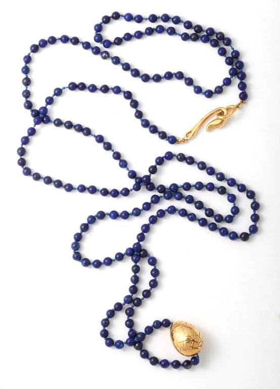 Long hand knotted Lapis Lazuli Necklace with a Large heavy 18kt Yellow Gold Engraved Bead and classical Angela Cumming's swan closure.  Dated 1983 & signed Cummings 1983