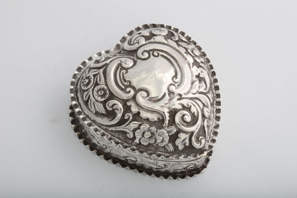 Sterling silver, heart-shaped trinkets box, Chester, England, 1895. Lightly gilt inside; 3" deep x 3" wide (at widest point) x 1 “high; 1.90 troy ounces. Very good condition, having one very small "dimple" in the vacant cartouche.