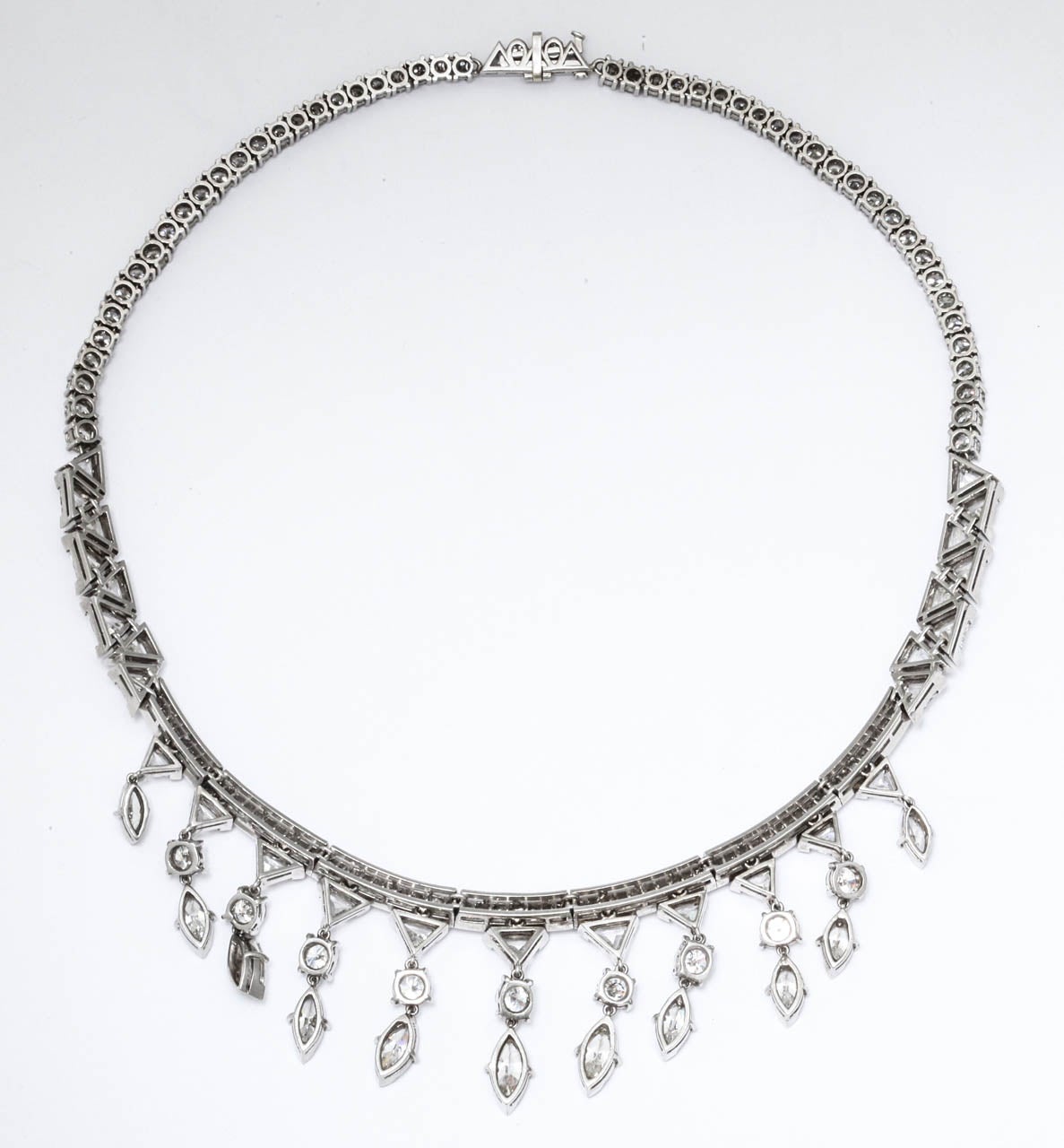 A Vintage Platinum and Diamond Necklace containing 61 round brilliant diamonds weighing approximately 10.35 carats total, 30 triangular shape step cut diamonds weighing approximately 9.25 carats total, 65 straight baguette cut diamonds weighing