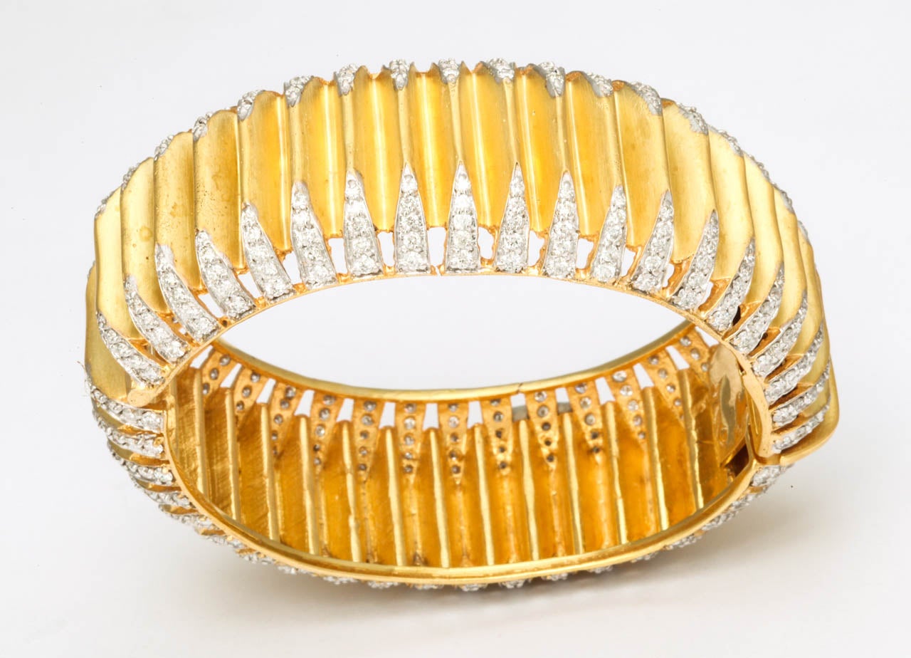 Sterling Silver bangle, plated on 24k yellow gold in a satin finish features 400 diamonds weighing approximately 9.25 cts