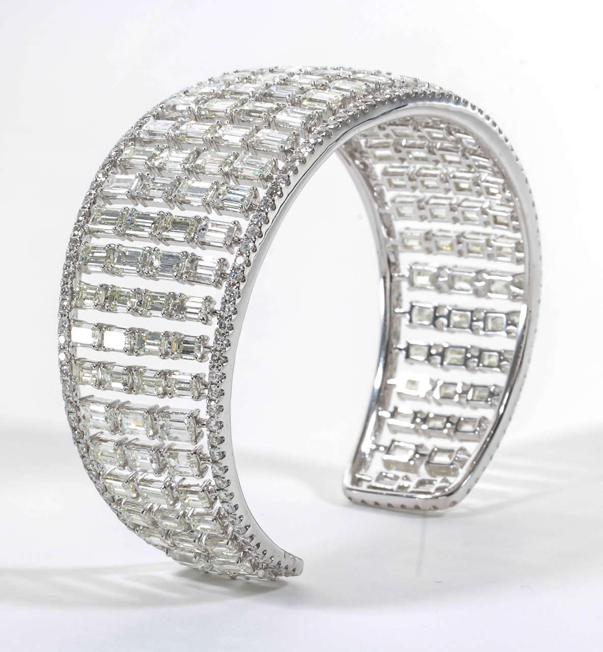 A rare find and exquisite design!

28.21 carats of emerald and round brilliant cut diamonds set in 18k white gold.

The bangle measures an inch at its widest point before graduating down on each side.
