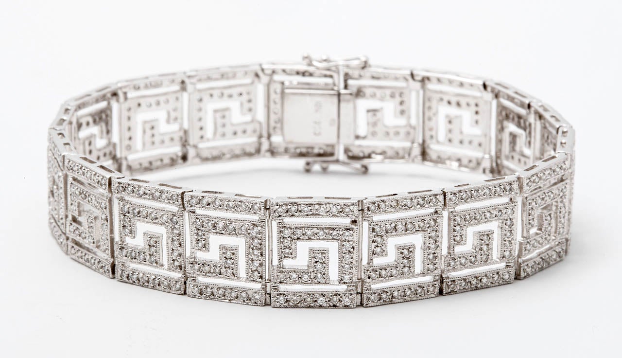 A white gold and diamond bracelet, the openworked hinged links decorated with meander motifs and set with brilliant-cut diamonds, with a total diamond weight of approximately 2.70 ct.