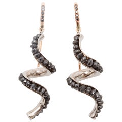 A Pair of Black Diamond White and Rose Gold Scroll Earrings