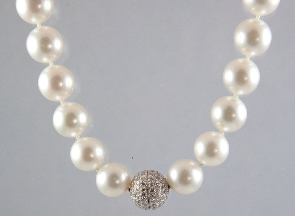 Beautiful strand of 29 perfectly matched South Sea pearls, white with rose overtone and excellent luster, measuring from approximately 13mm to 16mm, and completed by a platinum and diamond ball clasp containing 138 round briliant-cut diamonds, 3.15