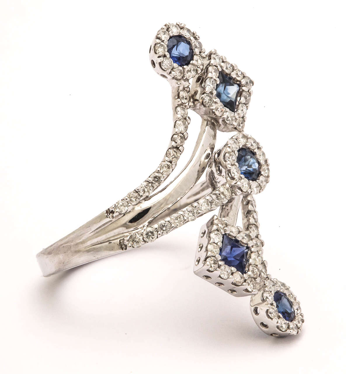 Gorgeous spray of blue sapphires and diamonds from knuckle to knuckle. There are 1.10 ct blue sapphires in round and square cuts and .85 cts white diamonds surrounding the sapphires and down the shank.
A great party ring!
