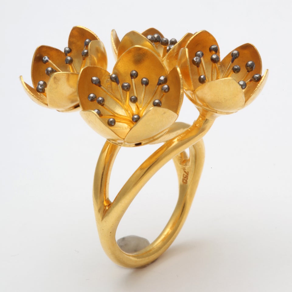 An 18kt yellow gold buttercup ring composed of four buttercup buds. Each buttercup is set with clusters of 18kt yellow gold stamen topped with rhodium plated sterling silver beads. Size 6.5
Flower Height: .50 inch
Width: 1.30 inches