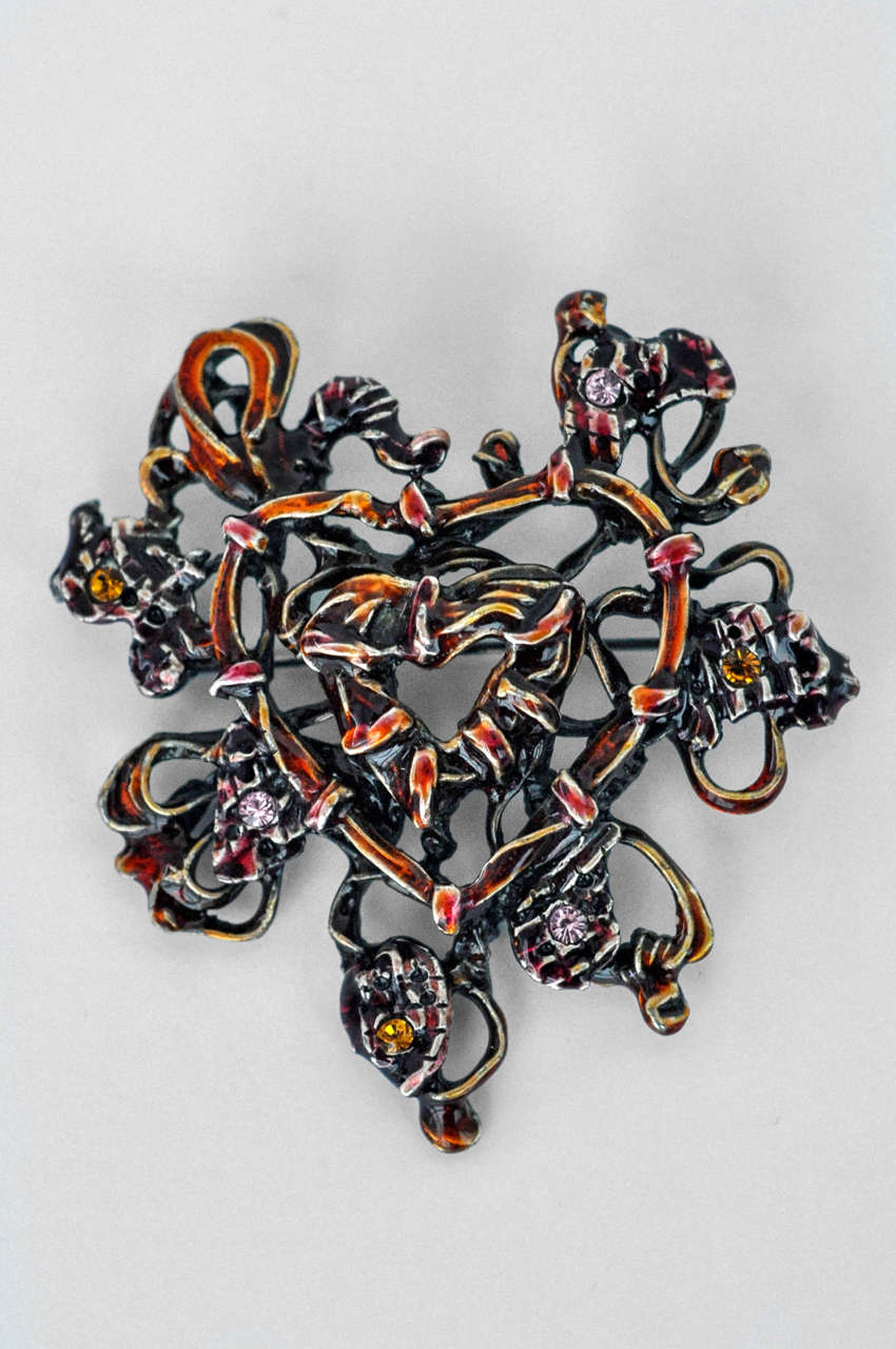 Lacroix combines an orange enameled metal heart form with pink and citrine-colored rhinestones to create a very sculptural brooch.  A complex, fascinating  jewelry design.  Signed.