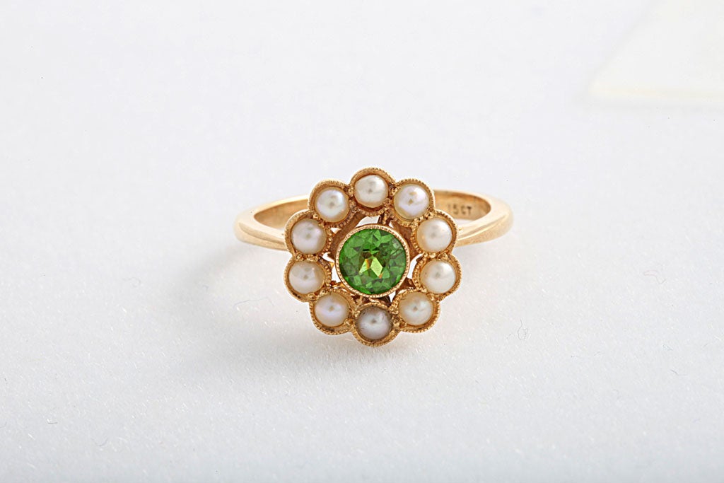 Delightful English ring featuring a .50c demantoid garnet surrounded by 10 pearls.  Size 6.