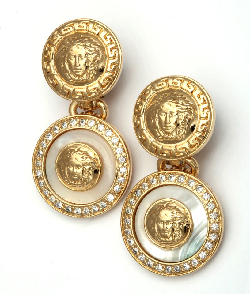 Gianni Versace white and gold dangling earrings with iconic Medusa motifs.