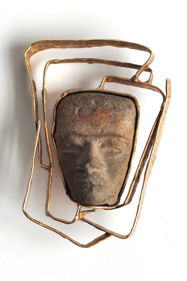 Hand-wrought studio piece that incorporates a carved Pre-Columbian stone artifact into a 14K gold setting.  A powerful brooch, beautifully crafted.   Marked.