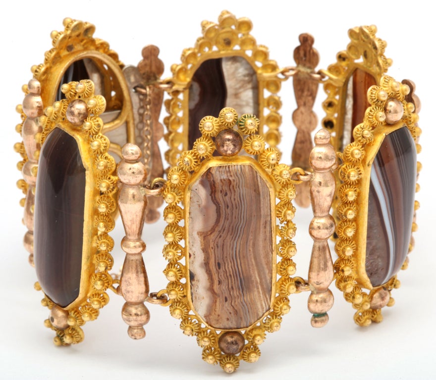 There are times when man can enhance nature as he did when placing naturalbanded agates from various parts of the earth with the golden metal created by Christopher Pinchbeck. Genuine Pinchbeck Rosettes frame earth toned agates that are separated by