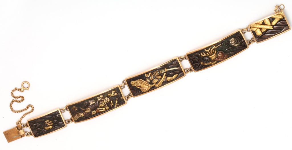 Rectangular links form this bracelet,  each depicting a different symbolic scene.  Shakudo was an art form of Japanese metal workers. Sometimes called mixed metals, this example is sterling silver,  highlighted in gold,  The images are in
fine