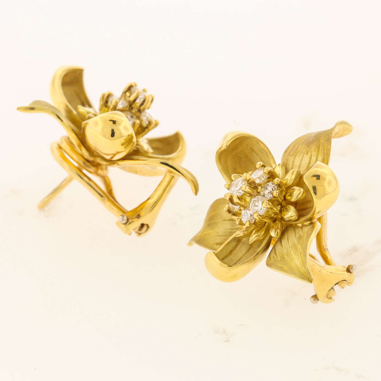 18K yellow gold flower earrings from Tiffany & Co. circa 2000,  are beautifully made and finished, inspired by the spring Trillum petals, with diamond centers, matte finished inner petals, high polished detail and backs, post and omega clips, the