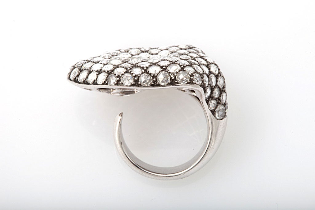 An 18kt white gold shield ring set with round rose cut diamonds. There are 6.42cts of diamonds.
The shank is open so this ring is easily sized.
Width: 1:00 inch